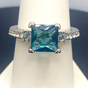 This silver tone Swiss blue topaz color princess cut stone with crystals on side